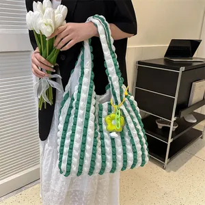 Detail of green and white bubble plaid tote bag with sunflower charm and green chain