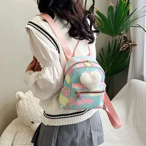 Detailed back view of a colorful tie-dye mini nylon backpack with a plush heart charm