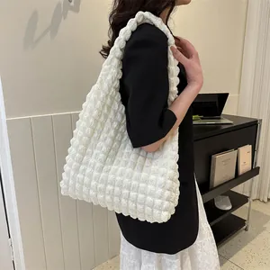 Detail of white popcorn texture tote bag showing puffy fabric and large capacity on shoulder