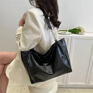 Detailed side view of black large-capacity tote bag with chain strap and contrast stitching