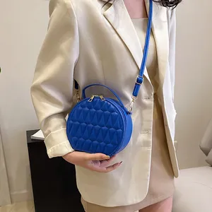 Détails du sac bandoulière en cuir bleu avec motif géométrique et garniture dorée