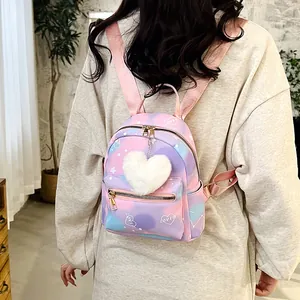 Detail of a pastel tie-dye nylon backpack featuring white heart motifs and a plush charm