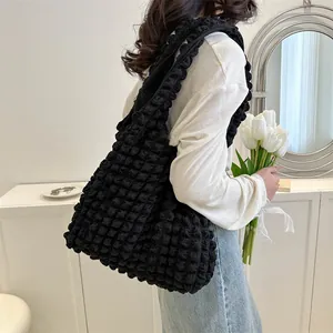 Black popcorn texture tote bag worn by model, showing large capacity and quilted design