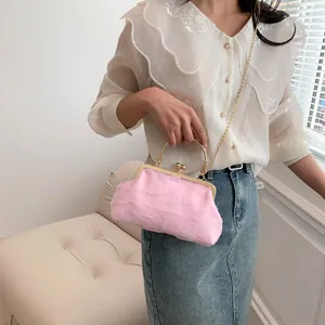 Detail of pink pleated dumpling bag with vintage gold metal handle and clasp closure