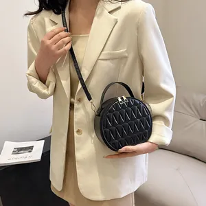 Détail du sac à main matelassé noir avec double fermeture éclair et crochets dorés