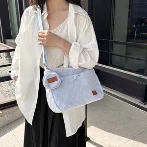 Quilted canvas tote bag with drawstring detail and matching round coin purse on a model