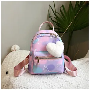 Close-up of a gradient nylon backpack with white star prints and a plush heart charm