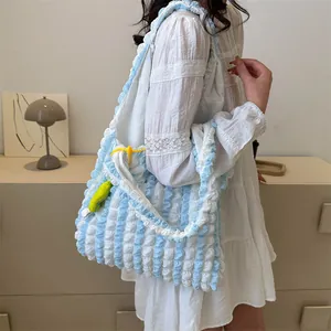 Close-up of cloud-textured popcorn fabric on light blue floral shoulder bag with charms