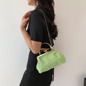 Detail of light green pleated dumpling bag with vintage gold metal chain and clasp