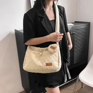 Detail of beige quilted canvas tote bag set with detachable round coin purse on model