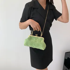 Detail of light green pleated dumpling bag with golden metal handle and chain strap