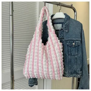 Detail of pink and white striped tote bag with bubble crinkle texture on a clothes rack