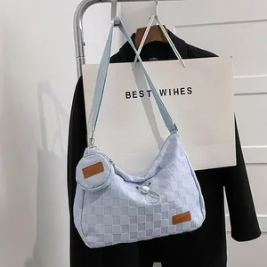 Close-up of light blue checkered hobo canvas bag with adjustable strap and coin purse