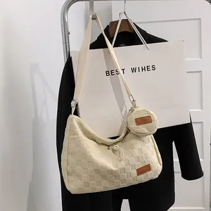 Detail of cream canvas tote bag featuring checkered texture and small round coin purse