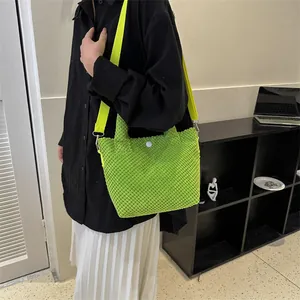 Primer plano del bolso verde neón con textura de burbujas y correa de nailon amarillo