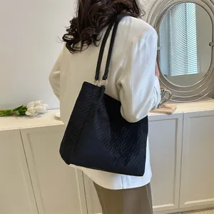 Détail du sac cabas matelassé noir avec motif à losanges et anneaux métalliques dorés