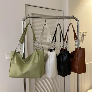 Detailed display of tote bags in green, white, black, and brown with metal chain straps