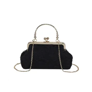 Elegant black ruched fabric evening bag with golden circular metal handle and chain strap