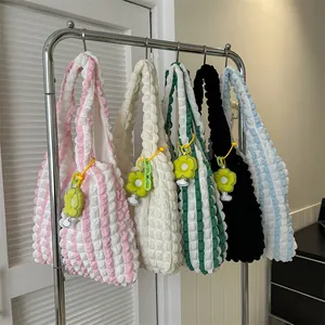 Detail of colorful popcorn texture tote bags with cute floral charms on metal hangers