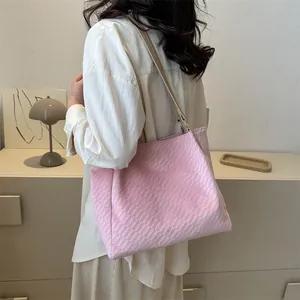 Détail de la texture gaufrée rose et de la bandoulière en cuir beige du grand sac