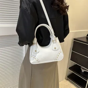 Borsa a mano retrò in pelle bianca a forma di luna con borchie dorate indossata da modella