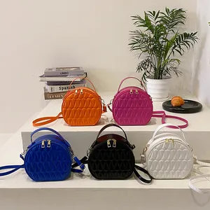 Vue détaillée de sacs bandoulière ronds colorés avec motif matelassé triangulaire
