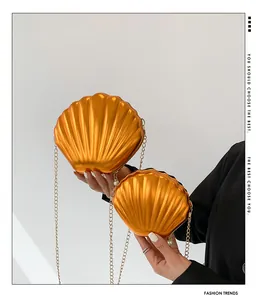 Detailed view of striped shell-shaped crossbody bags with gold chains and pearl zipper charms