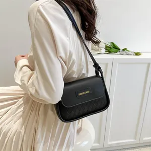 Detail of black quilted shoulder bag with matte leather finish and elegant lettering