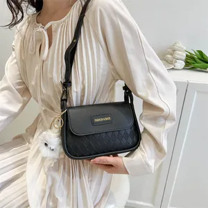 Quilted black leather shoulder bag detail with plush charm and fashion branding