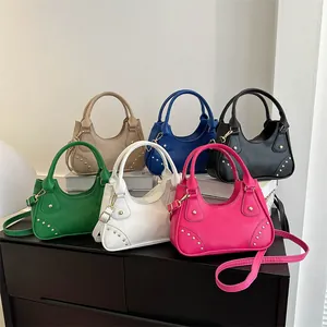 Dettaglio di mini borse stile moto in sei colori opachi con rivetti e tracolle