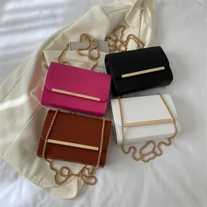 Sacs à bandoulière minimalistes en rose, noir, marron et blanc sur tissu blanc plissé