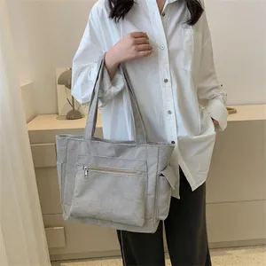 Détails du sac fourre-tout en velours côtelé gris clair avec poche zippée et rabat