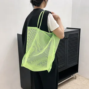 Vista detallada del bolso tote grande de malla verde flúor con costuras reforzadas