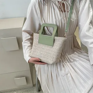 Sac seau minimaliste en paille tressée avec anses et bandoulière en cuir vert clair
