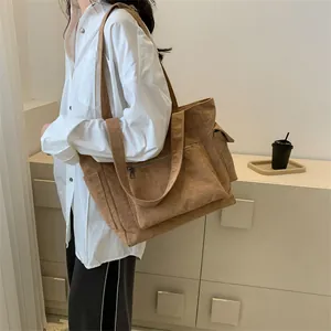 Détails du sac fourre-tout en velours marron avec poches latérales et bandoulières
