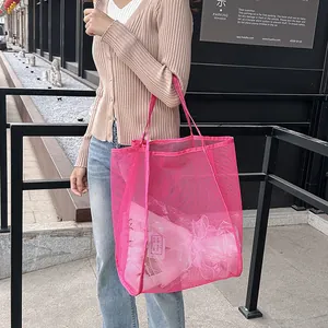 Vista de primer plano del bolso de malla rosa con textura transparente y asas anchas rosas