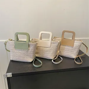 Vue détaillée des sacs seaux en paille tissée en vert menthe, blanc crème et caramel