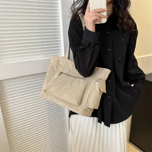 Détail du sac cabas en velours côtelé beige avec poche frontale zippée et rabat latéral