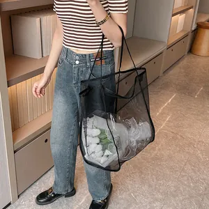 Detalle del bolso tote de malla negra con textura fina y gran capacidad de carga