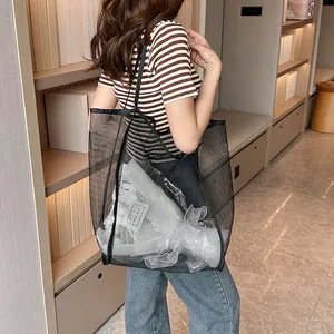 Detalle del bolso tote de malla negra que muestra gran capacidad y textura transparente