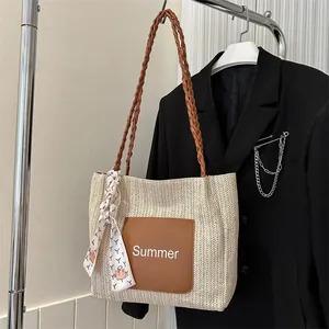 Close-up of woven straw tote bag with Summer patch and decorative floral silk scarf