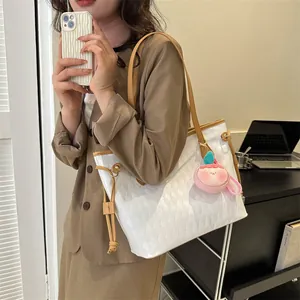 Détail du sac cabas blanc matelassé avec charme pêche rose et bandoulière marron