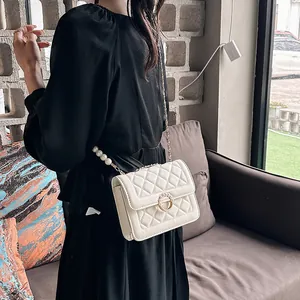 Modern white quilted chain bag with elegant pearl strap and ring clasp detail