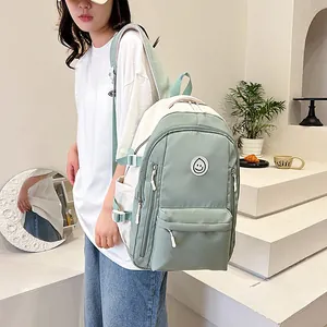 Dettaglio dello zaino oxford verde con fibbie laterali e toppa con faccina sorridente