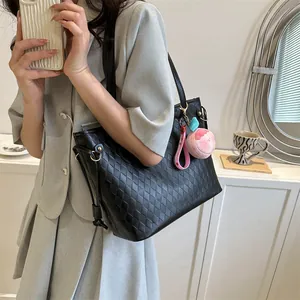 Détail du sac cabas matelassé noir avec porte-clés en peluche rose et fines anses