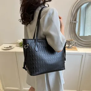 Grand sac cabas noir matelassé avec détails de pompons et cordon pour un look chic