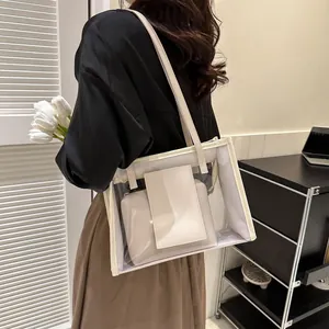 Detailed close-up of a clear PVC tote bag with cream leather trim shown on a shoulder