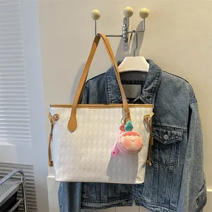 Détail du sac cabas matelassé blanc avec anses marron et pendentif en peluche pêche mignon