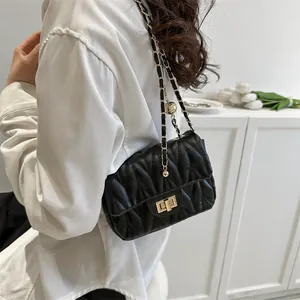 Detail of black quilted shoulder bag featuring gold twist-lock and wave texture