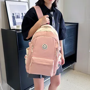 Dettaglio dello zaino Oxford rosa e beige con logo smile e fibbie laterali regolabili
